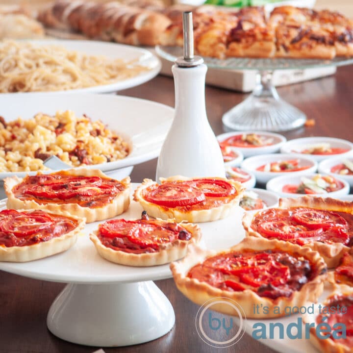 Een vierkante foto van een Italiaans buffet op een houten tafel met diverse gerechten