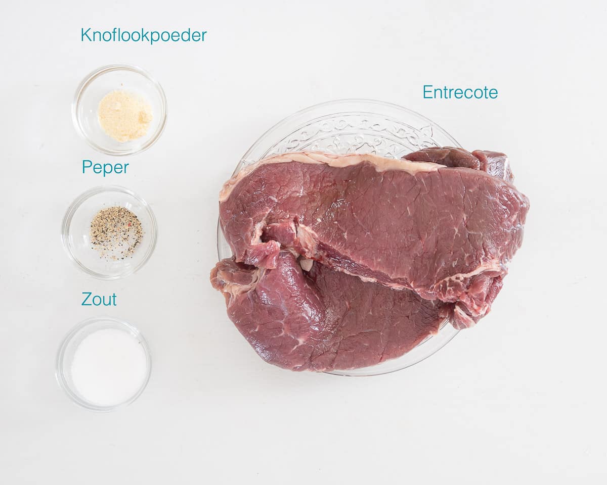 Individueel gelabelde ingrediënten om entrecote uit de Airfryer te maken op een witte ondergrond verspreid