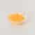 Een ei-geel in een glazen schaaltje op een witte ondergrond
