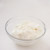 Griekse yoghurt in een glazen schaaltje op een witte ondergrond