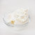 A glass bowl filled with mascarpone on a white background