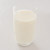 Een glas met melk op een witte ondergrond