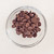 Milk chocolate chips in a glass bowl on a white background