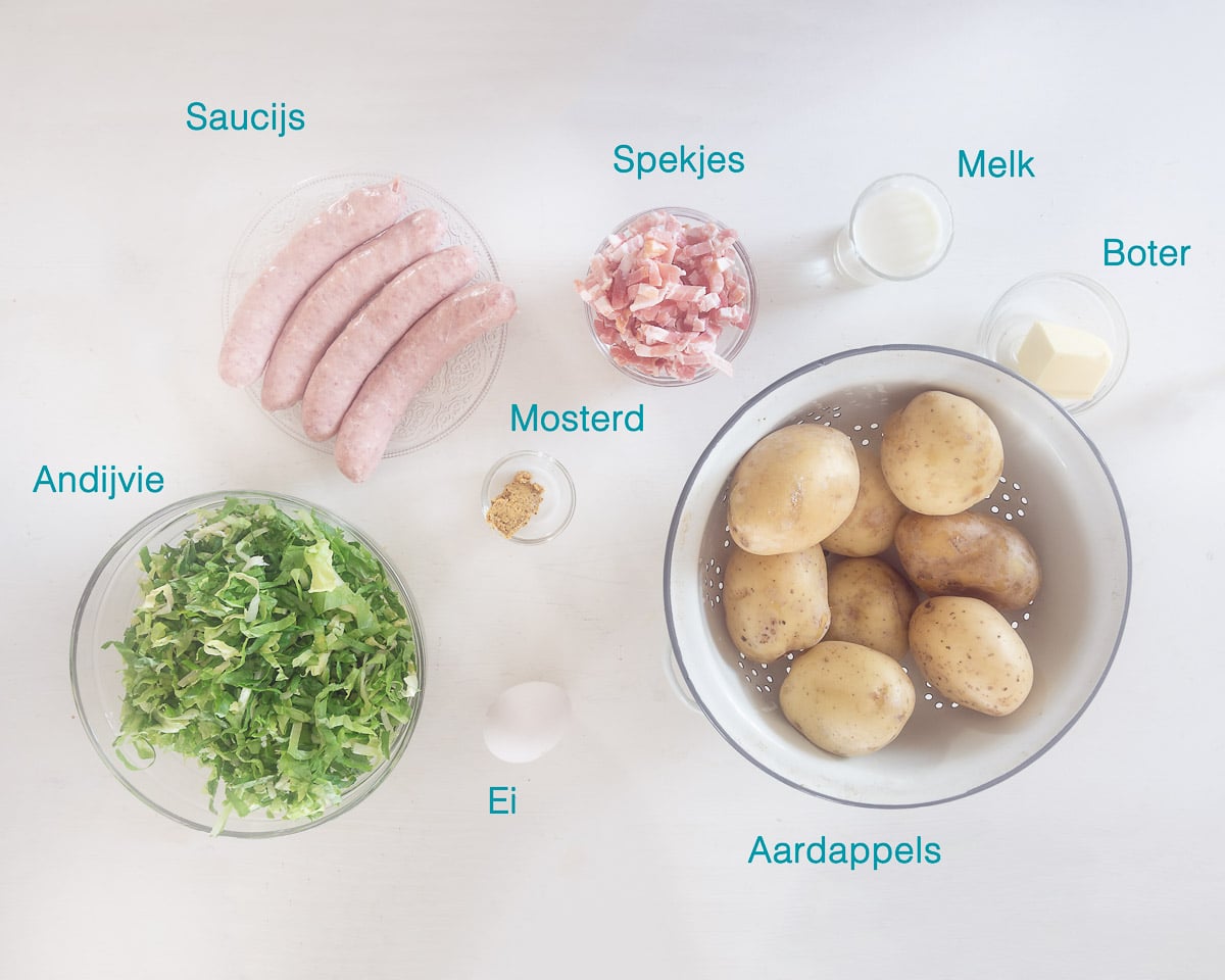 Ingrediënten Hollandse Andijviestamppot met Spekjes en Worst, individueel gelabeld op een witte ondergrond.