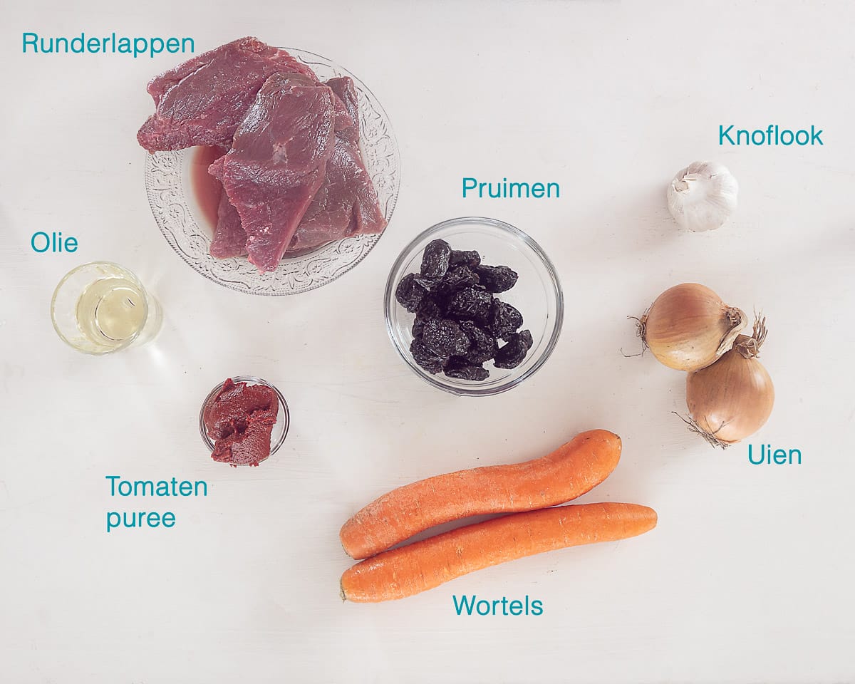 Ingrediënten Slowcooker Stoofvlees met Pruimen, individueel gelabeld op een witte ondergrond.