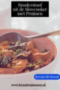 Een deel van een schaal met runderstoof met pruimen en groenten. Een tekst bovenin: Runderstoof uit de slowcooker met pruimen.