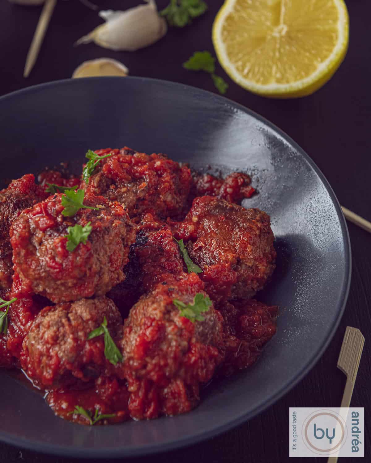 Een grijs schaaltje met albondigas, Spaanse gehaktballetjes in tomatensaus.