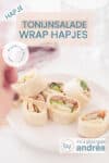 Een wit bord met zeven tonijnsalade wrap hapjes, een hand prikt een hapje. Bovenin een tekstoverlay: hapje, tonijnsalade wrap hapjes, makkelijk recept, snack