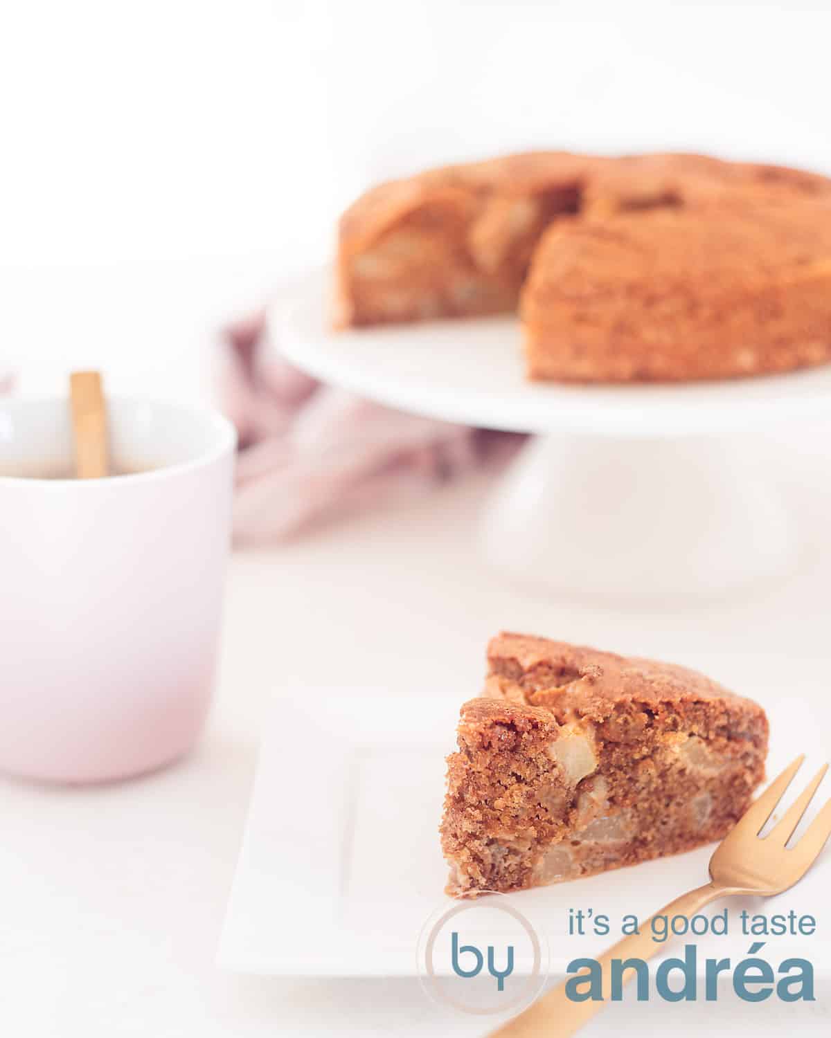 Een hoogtefoto met in de voorgrond een punt cake met peren, in de achtergrond een witte cakestandaard met de rest van de taart. Links een roze kopje koffie