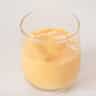 A glass bowl filled with Advocaat on a white background