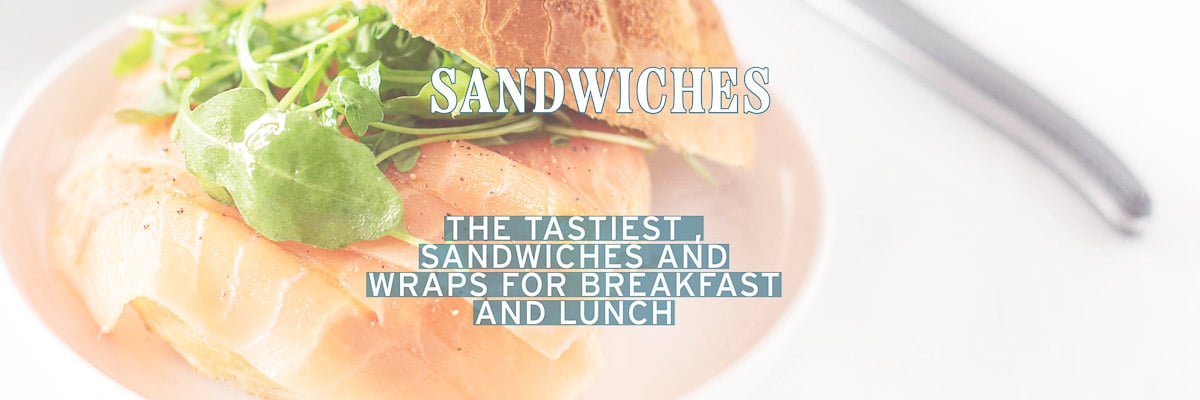 Part of a bun with smoked sandwich and arugula. A text overlay: sandwiches, the tastiest grilled cheese sandwiches, wraps and sandwiches for breakfast and lunch 