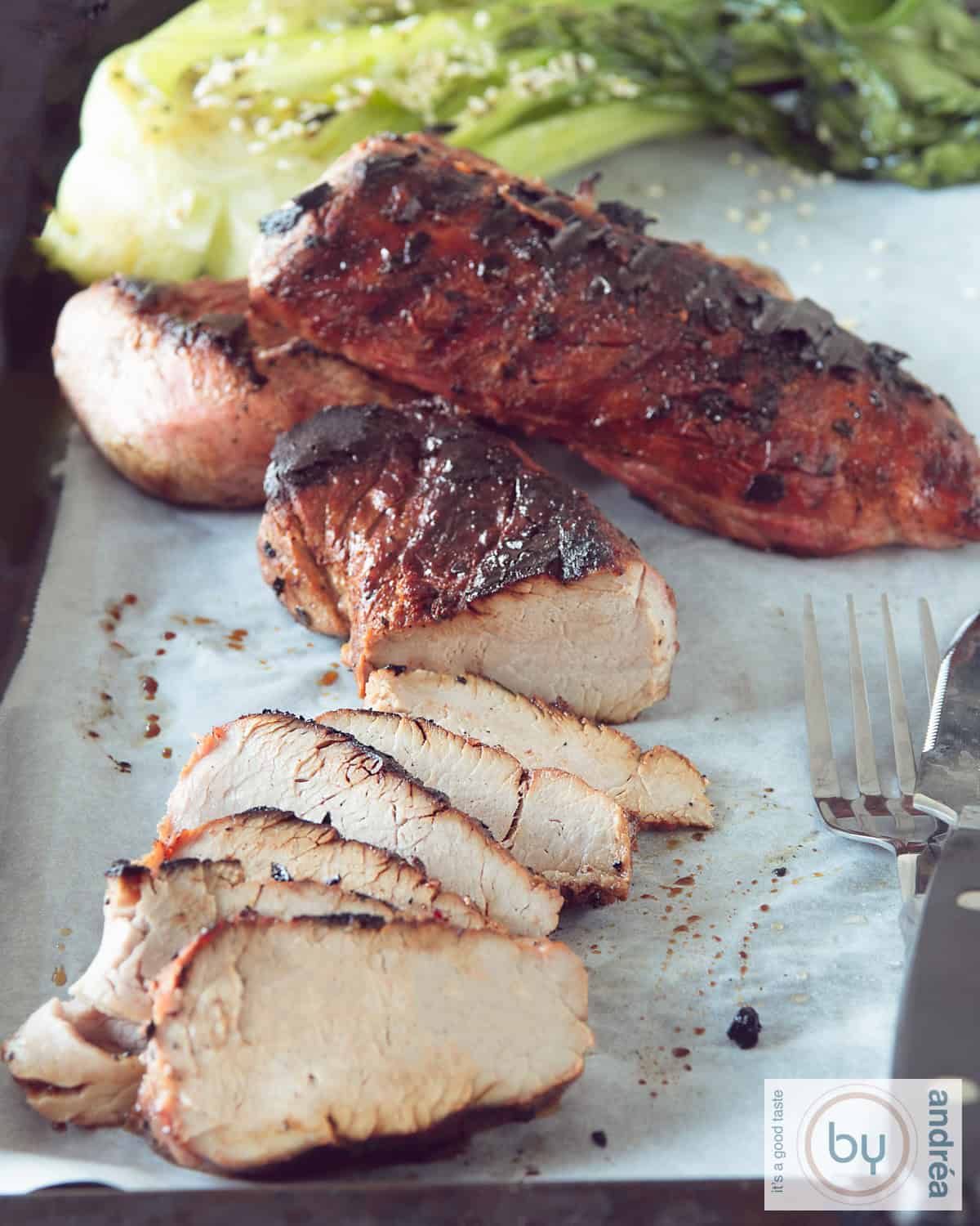 Een foto van een bakplaat met Char siu, 1 in plakjes gesneden, Paksoi in de achtergrond