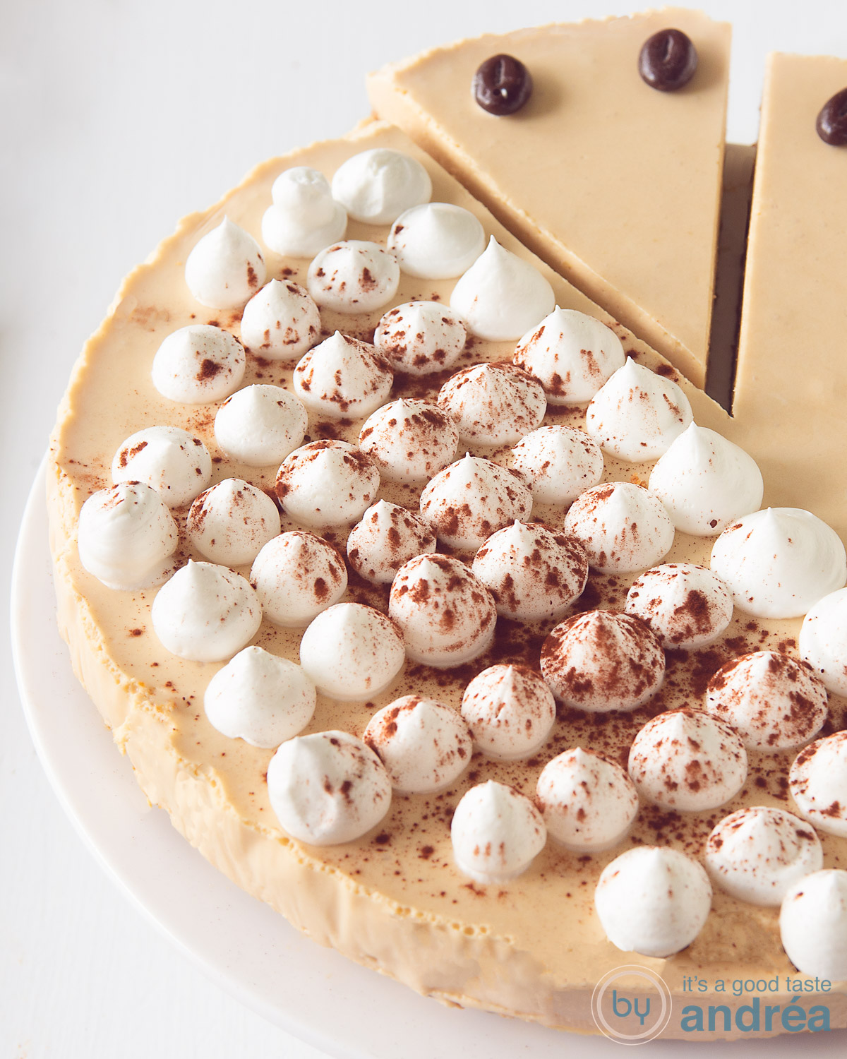 Irish coffee taart met een stukje eruit gesneden op een witte ondergrond