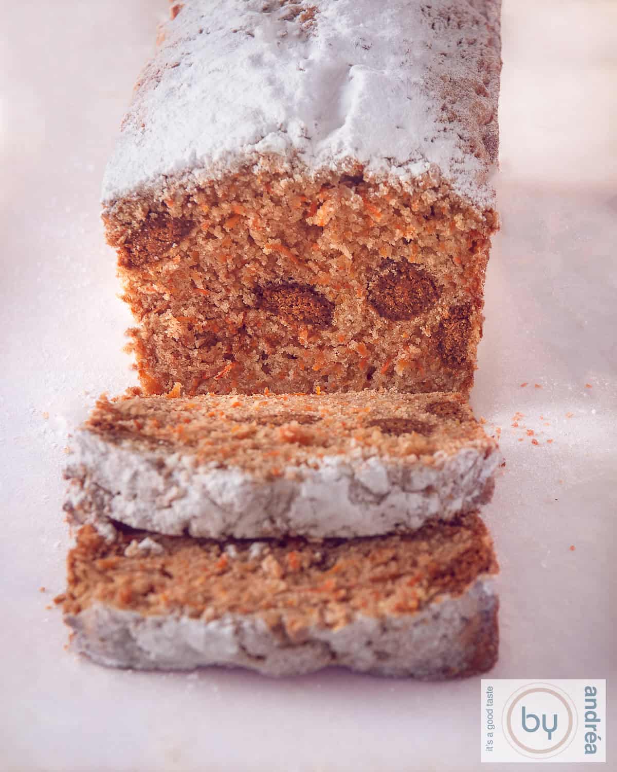 Wortelcake met pepernoten op een witte ondergrond. Twee plakjes zijn afgesneden