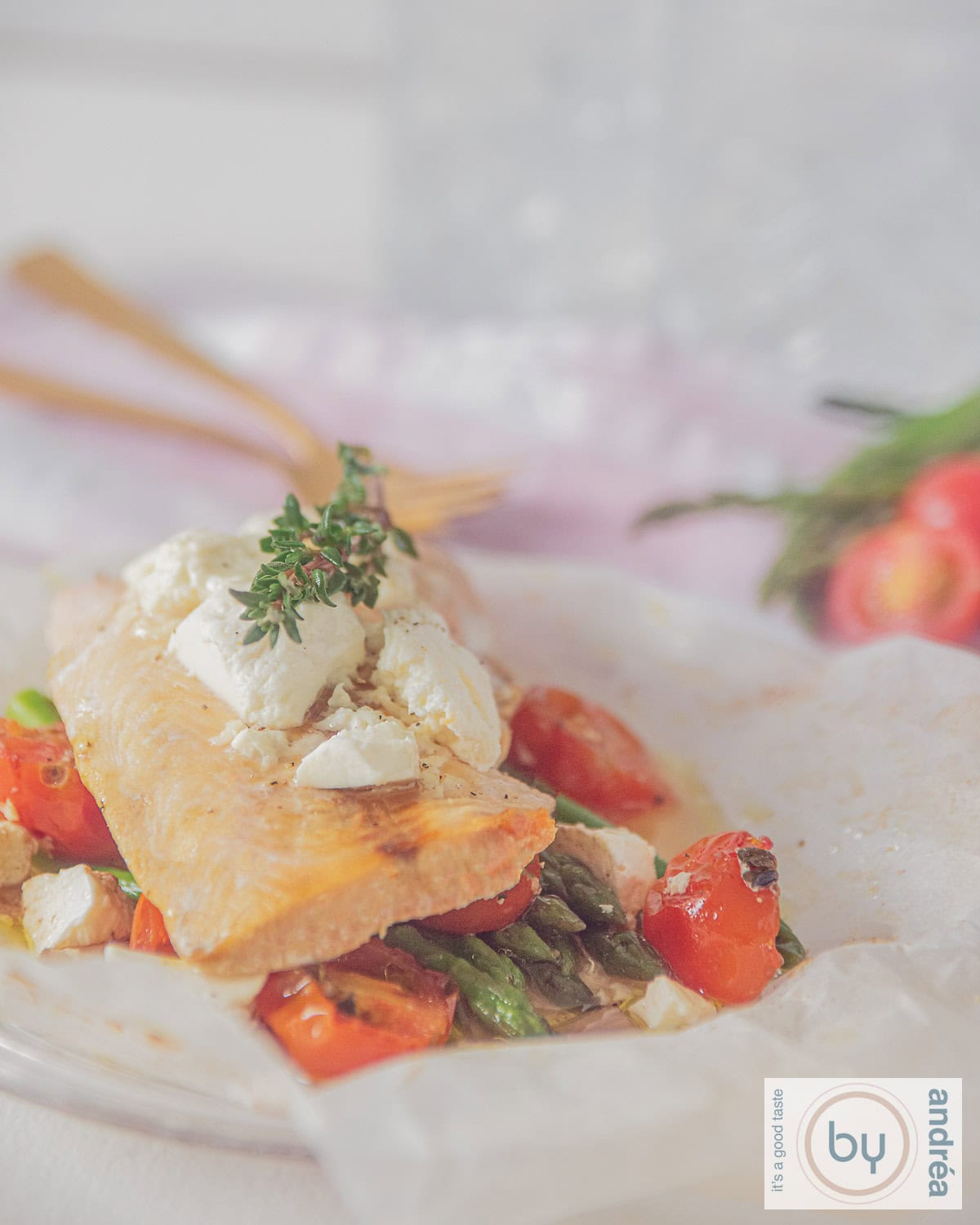 Zalm uit de oven met asperges en tomaatjes op een wit bakpapier