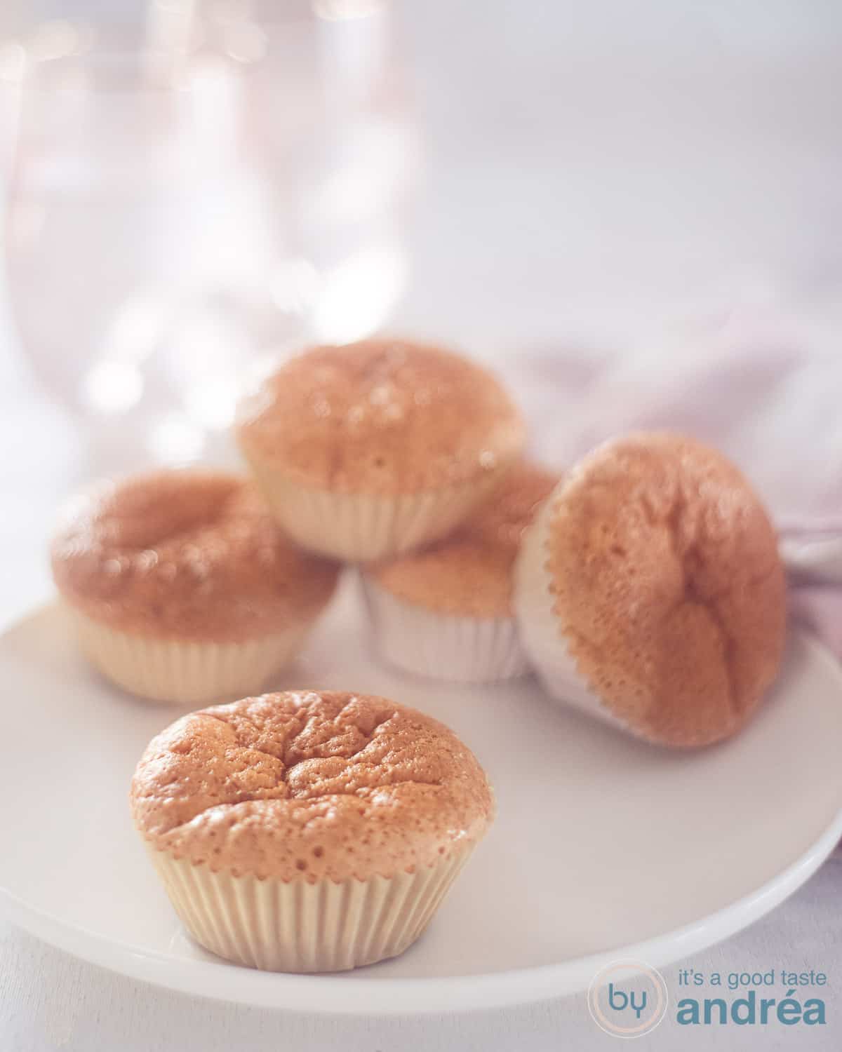 5 Zoete melk cupcakes op een wit bord. Een cupcake voorin, de rest achterin opgestapeld.