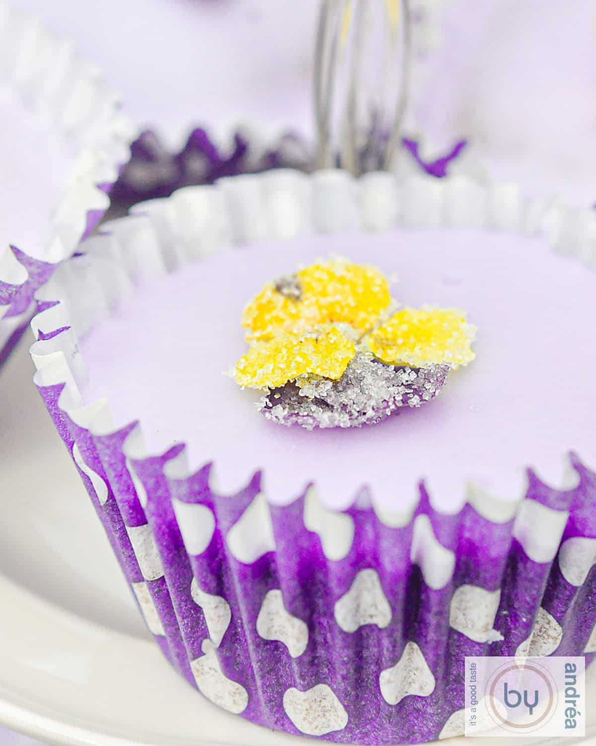lavendel cupcake op een wit bord met een suikerbloem