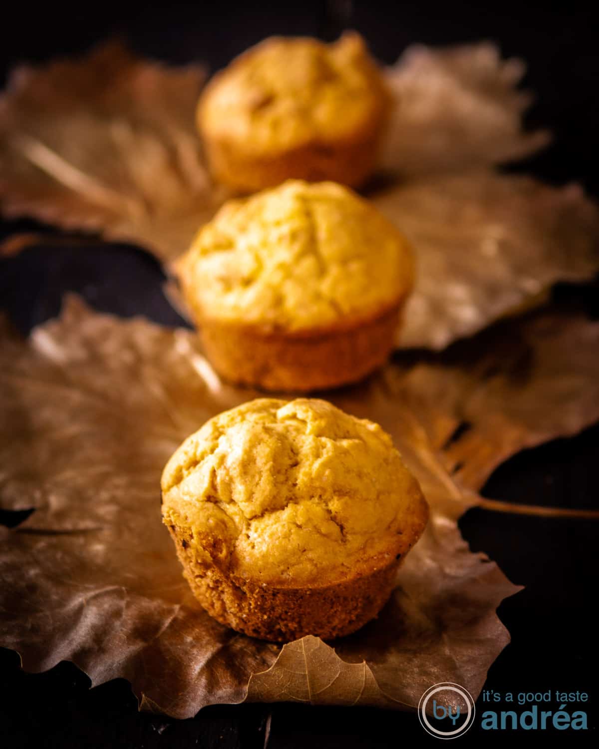 3 mais muffins op een rij op gouden blaadjes