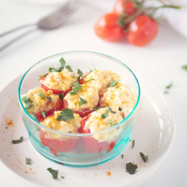 a bowl with With egg salad stuffed tomatoes