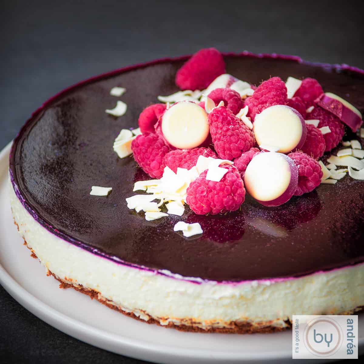 witte chocolade cheesecake met bastognekoek en bosvruchten van de zijkant gefotografeerd. Een vierkante foto