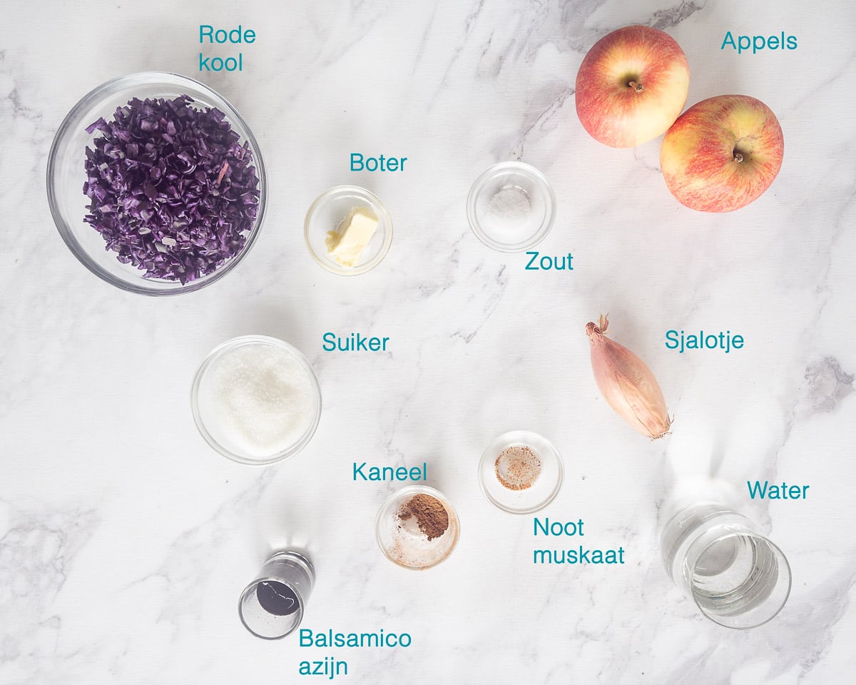 Ingrediënten Rode Kool met Appeltjes Recept, individueel gelabeld op een gemarmerde witte ondergrond.