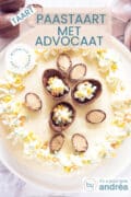 Een no bake cheesecake met slagroom en advocaat op een witte ondergrond. Chocolade eieren zijn de topping. Een text overlay met daarop Taart, paastaart met advocaat, makkelijk recept, Pasen