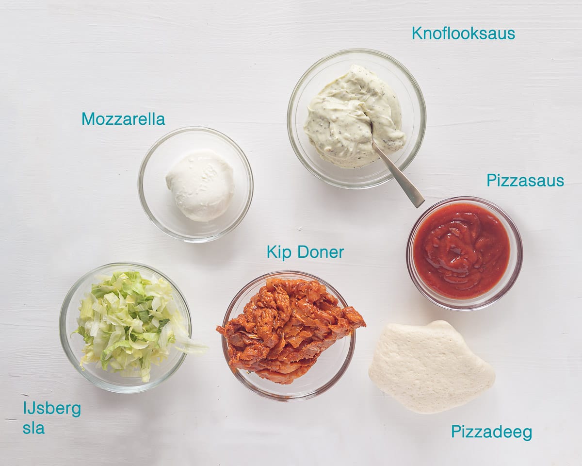 Ingrediënten Pizza met Kip Kebab en Knoflooksaus, individueel gelabeld op een witte ondergrond