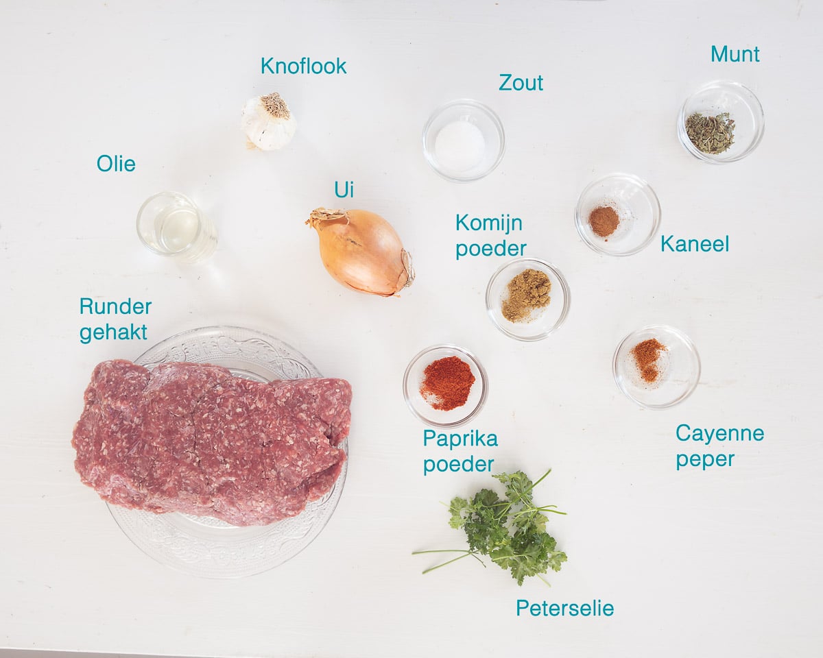 Ingrediënten Zelf Köfte Kebab Maken, individueel gelabeld op een witte ondergrond