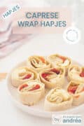 Rechtsonderin een wit bord met Caprese wrap hapjes met tomaat, mozzarella, pesto en basilicum. Bovenin een textoverlay: caprese wrap hapjes, hapjes, makkelijk recept, Italiaans