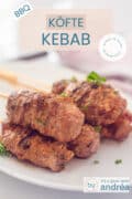 Een deel van een witte schaal met kofte kebab. Bovenin een tekstoverlay: Kofte kebab, bbq, makkelijk recept, wereldkeuken