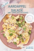A pink plate photographed from above with potato salad with Cheddar and Bacon. At the top a text overlay: Cheddar bacon potato salad, salads, easy recipe, side dish.