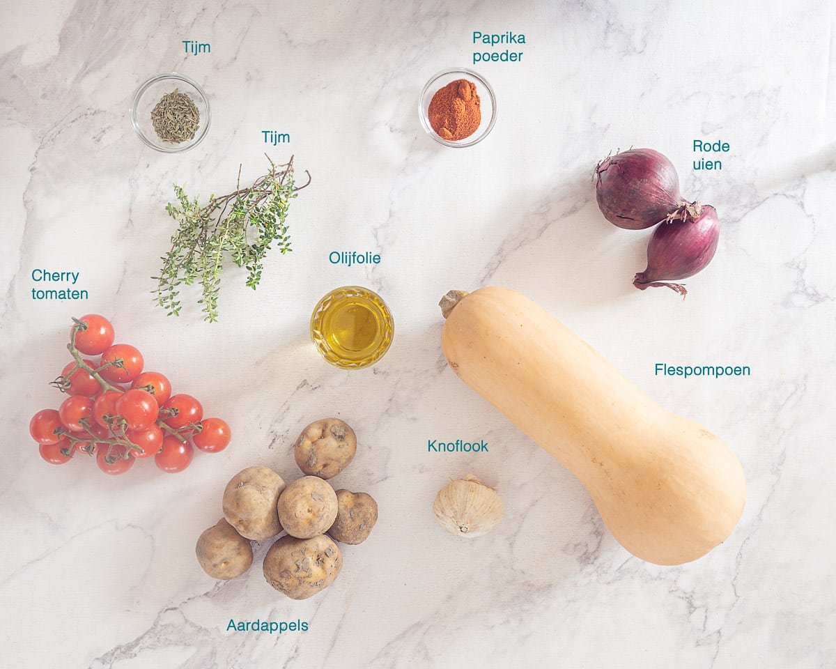 Ingrediënten Pompoen Traybake met Aardappel en Tomaatjes, individueel gelabeld op een witte ondergrond