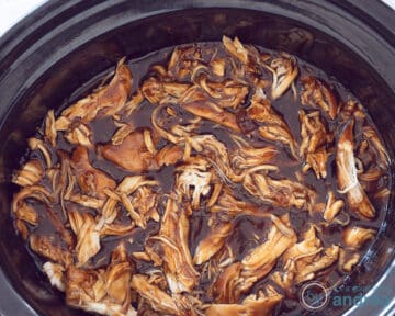 Een slowcooker gevuld met pulled chicken.