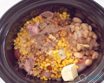Aan het vlees wordt ui, mais en boter toegevoegd in de slowcooker.