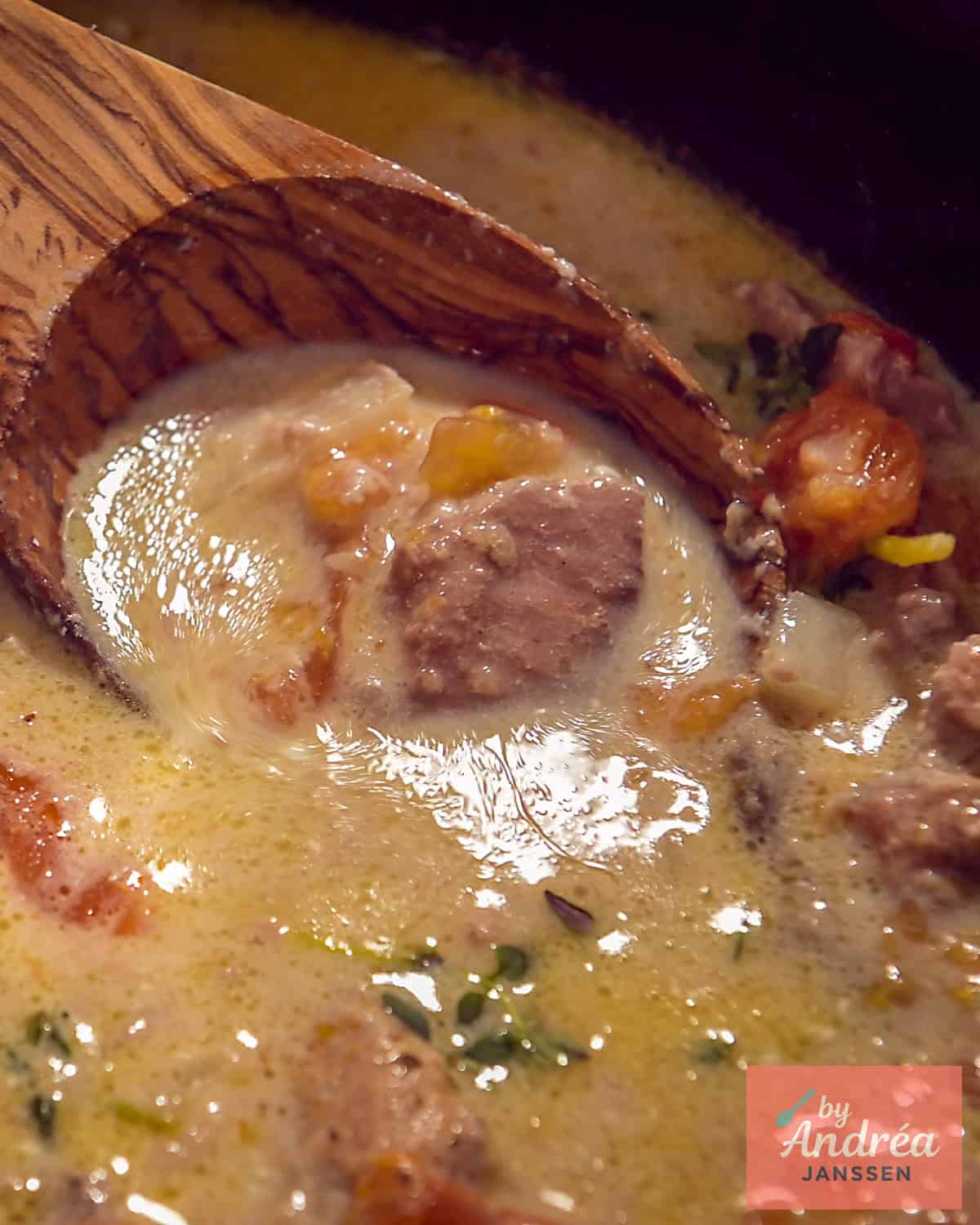 Een deel van een slowcooker met hamlappen in een romige saus