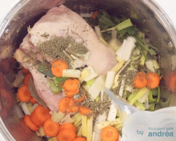 Water is poured into the pan with the chicken, vegetables and herbs