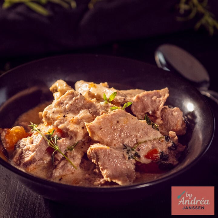 Een vierkante foto met een zwart bord met hamlappen in een heerlijke roomsaus