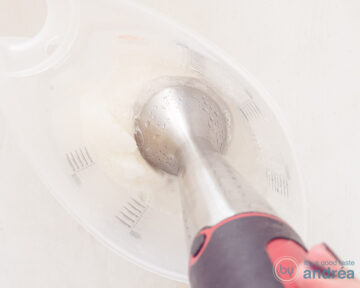 Een maatbeker met 7up en citroenijs waar een staafmixer instaat