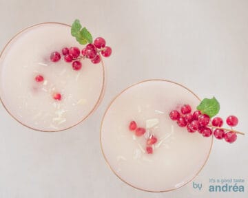 Twee glazen gevuld met scroppino en ggegarneerd met bessen, munt, chocola en granaatappelpitjes