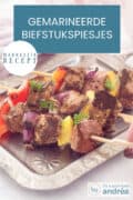 Een zilveren schaal met drie spiesjes met biefstuk, paprika en ui. Een tekst: makkelijk recept, gemarineerde biefstukspiesjes