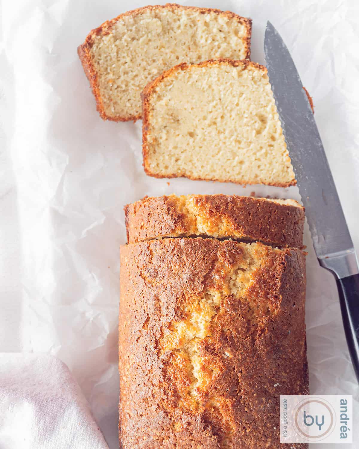 Een foto van bovenaf van een deel van een cake met appelmoes waar drie plakjes gesneden zijn en twee plakjes liggen plat.