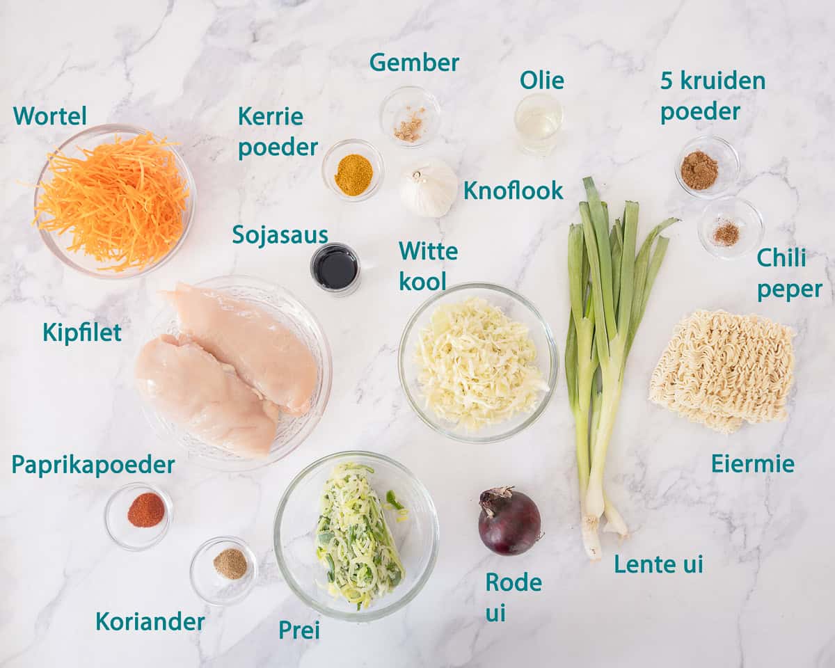 Ingredienten Kantonese Kip met Mie op een wit gemarmerde ondergrond met tekst beschrijving.