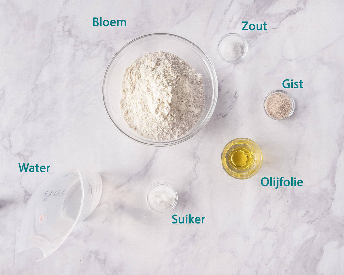 Ingredienten Zelf Snel Pizzadeeg Maken, individueel gelabeld op een marmeren ondergrond.