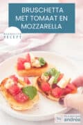 Een witte ondergrond met een wit rond bord met drie gegrilde stokbroodjes met mozzarella, tomatenblokjes en basilicum. Een tekst bovenin: makkelijk recept, bruschetta met tomaat en mozzarella