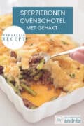 Een deel van een witte ovenschaal waar een hap is genomen waardoor de boontjes gehakt en aardappelpuree zichtbaar zijn. Een lepel pakt nog een hap. Een tekst: makkelijk recept, ovenschotel met gehakt