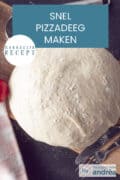 Een bol pizzadeeg op een houten plank. Een tekst: snel pizzadeeg maken, makkelijk recept