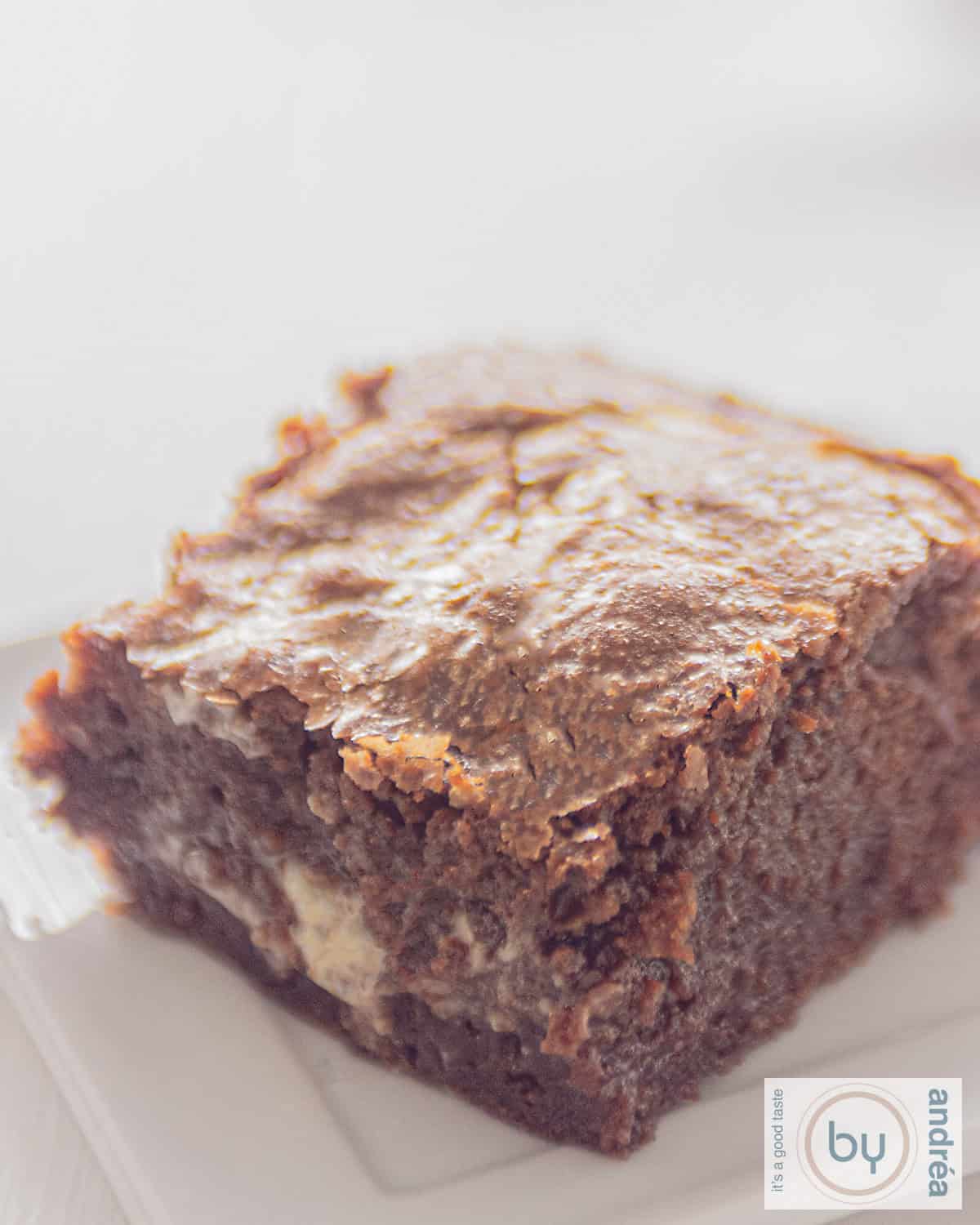 Een uitvergroting van een brownie gevuld met witte chocola op een witte ondergrond