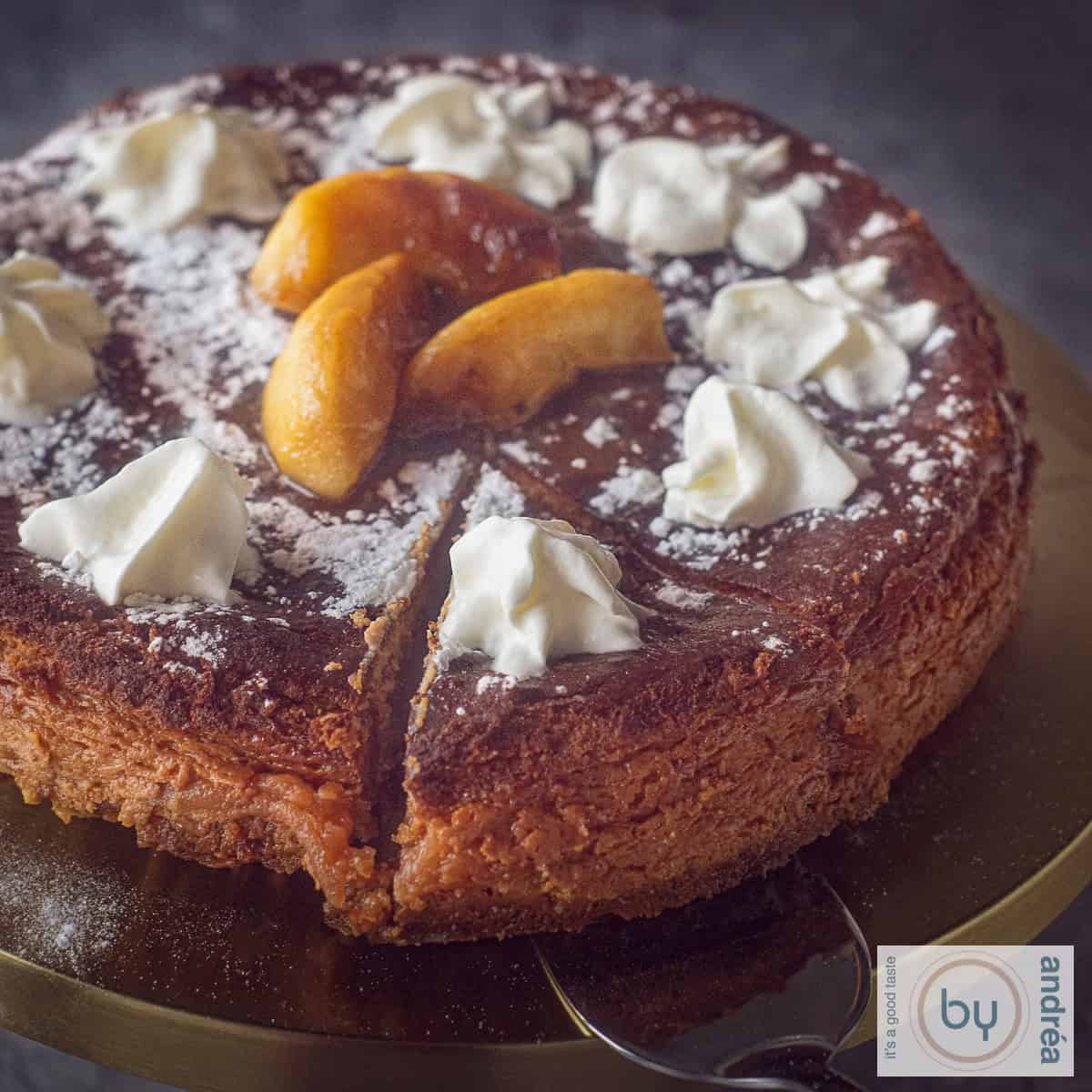 Een vierkante foto met een deel van een cheesecake met gekarameliseerde appeltjes. Gegarneerd met slagroom en poedersuiker.