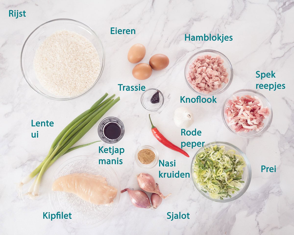 Ingredienten Nasi Goreng met Kip en Spek maken op een wit marmeren ondergrond met tekstbeschrijving
