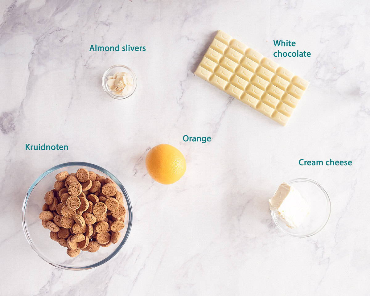 Ingredients pepernoten truffles with white chocolate on a white marble background with text description